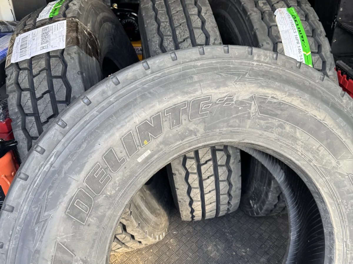 Close up of new tread on a commercial truck tire beside a mounted wheel