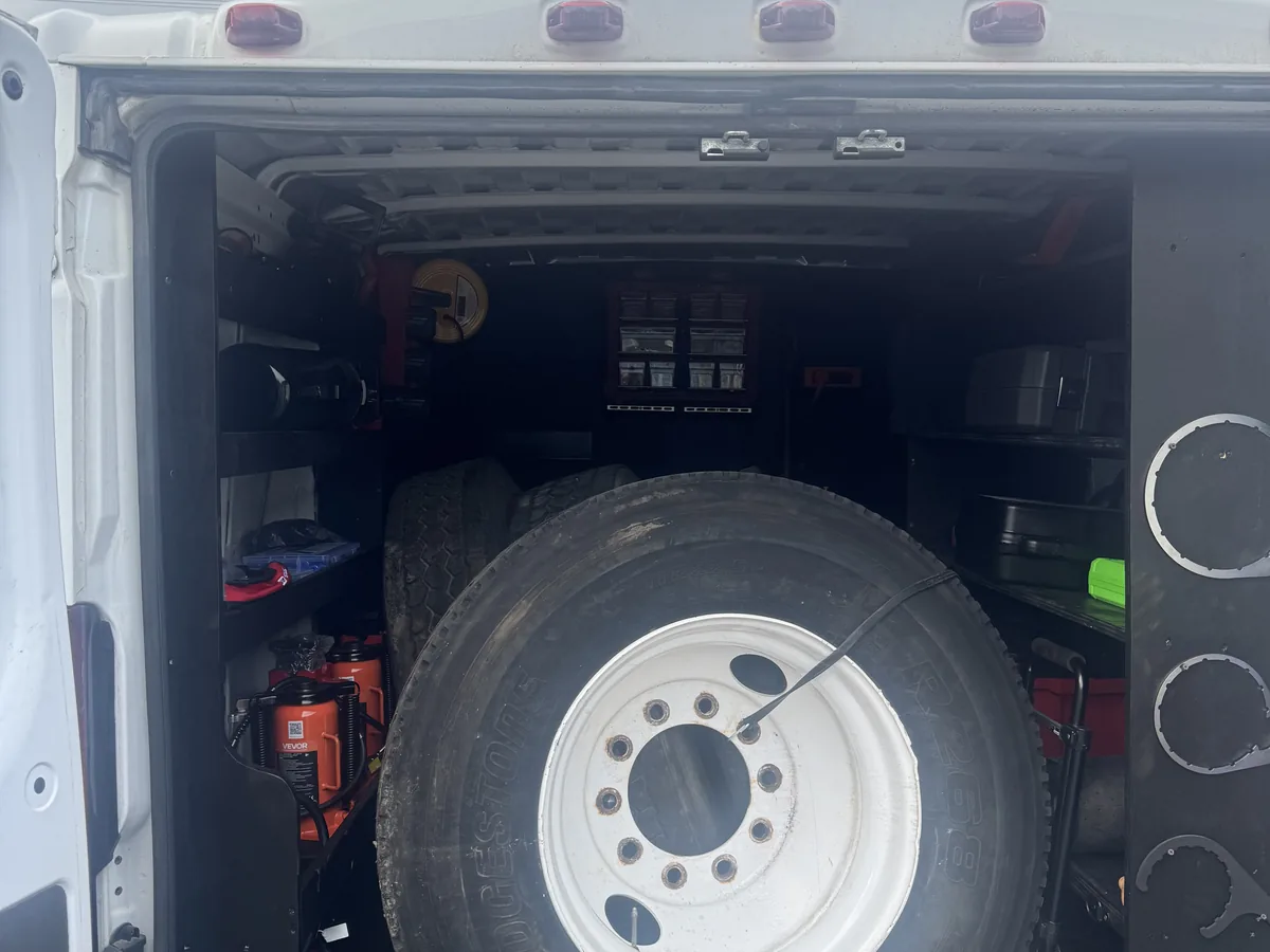 Truck wheel and tire loaded in the cargo area of a service van