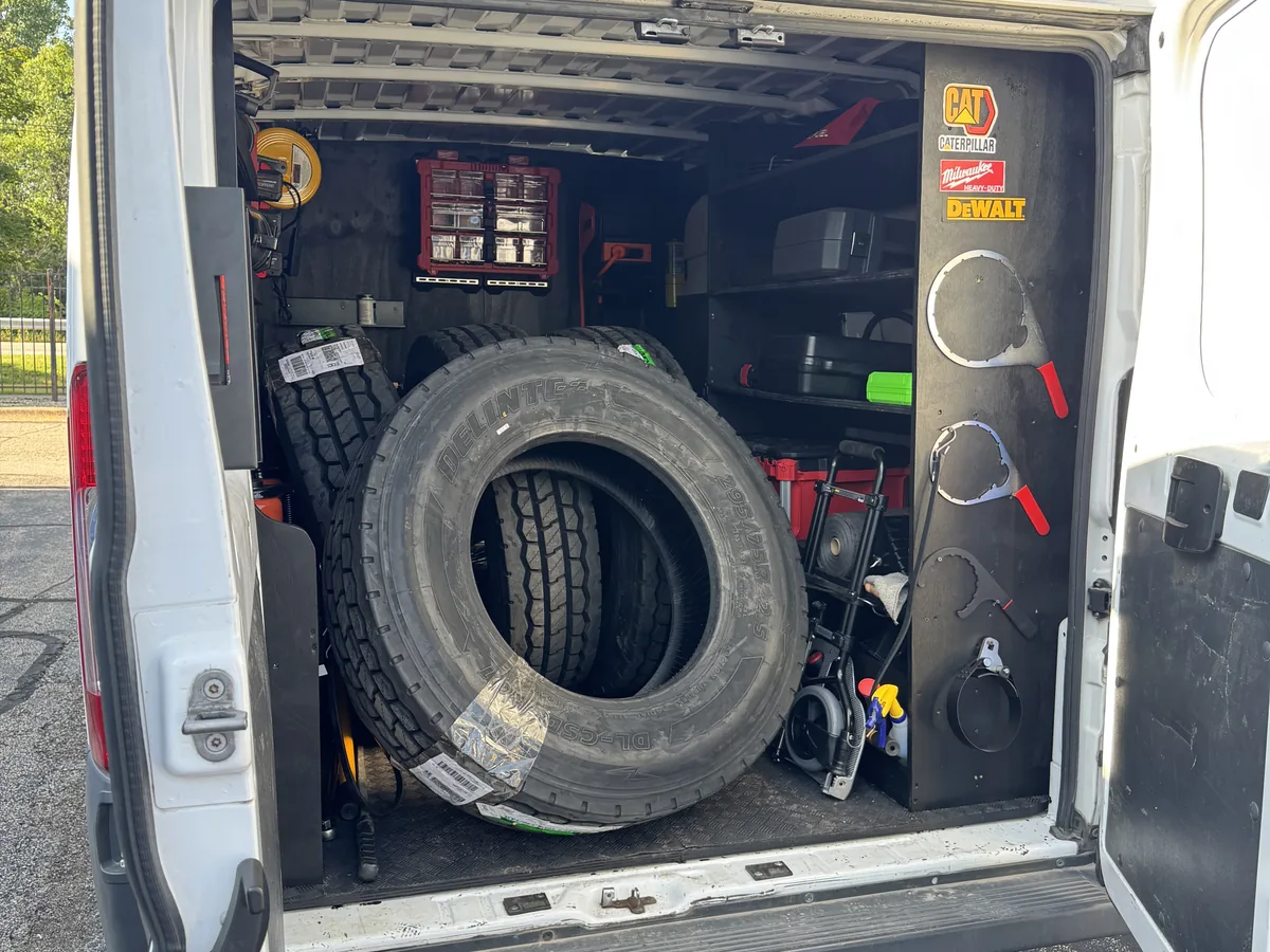 Spare tire and repair equipment secured inside a service van