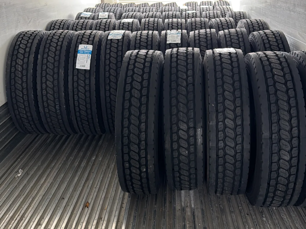 Stack of new commercial truck tires loaded in the bed of a service vehicle