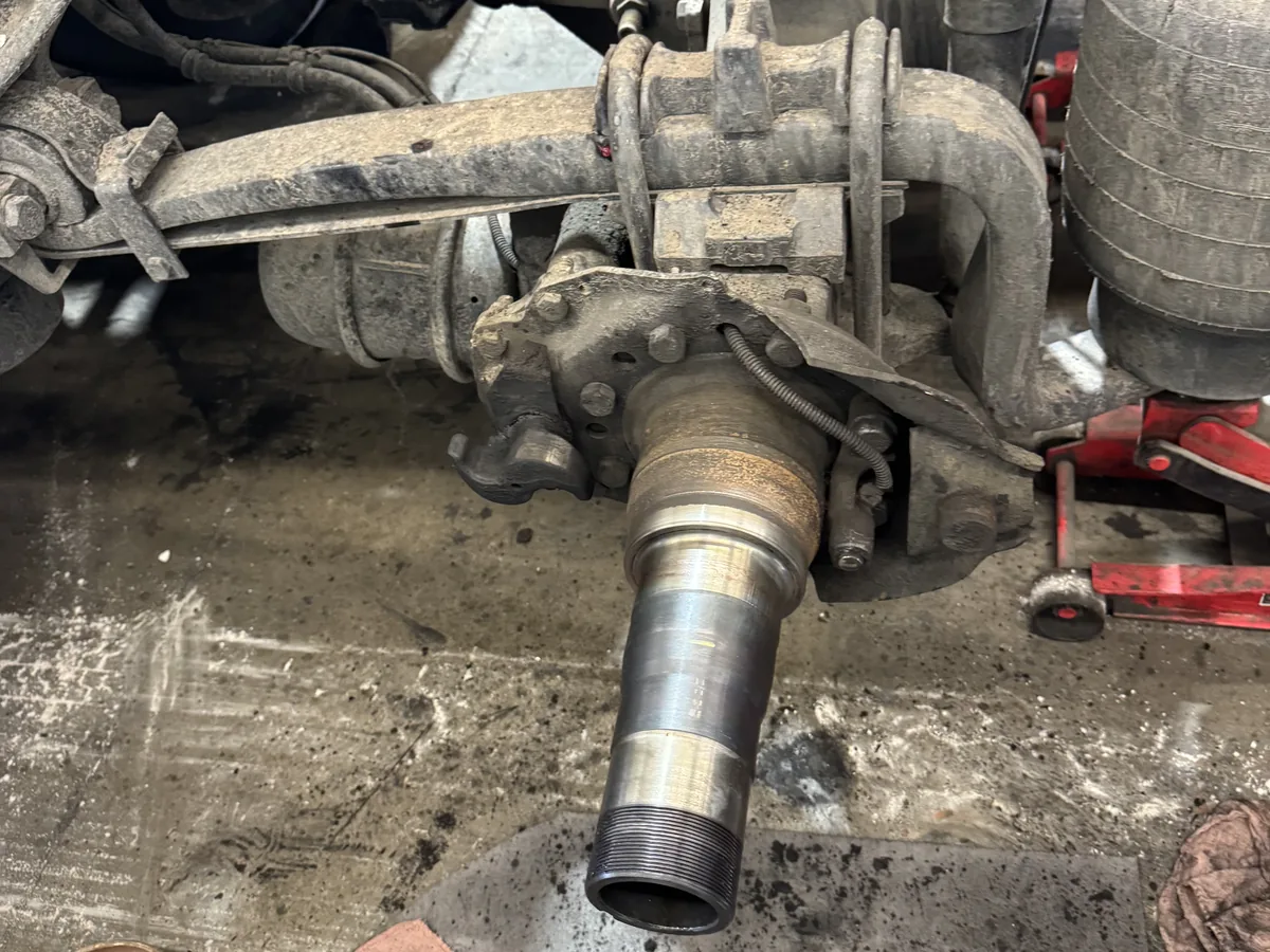 Bare axle spindle exposed with the hub removed and leaf spring above