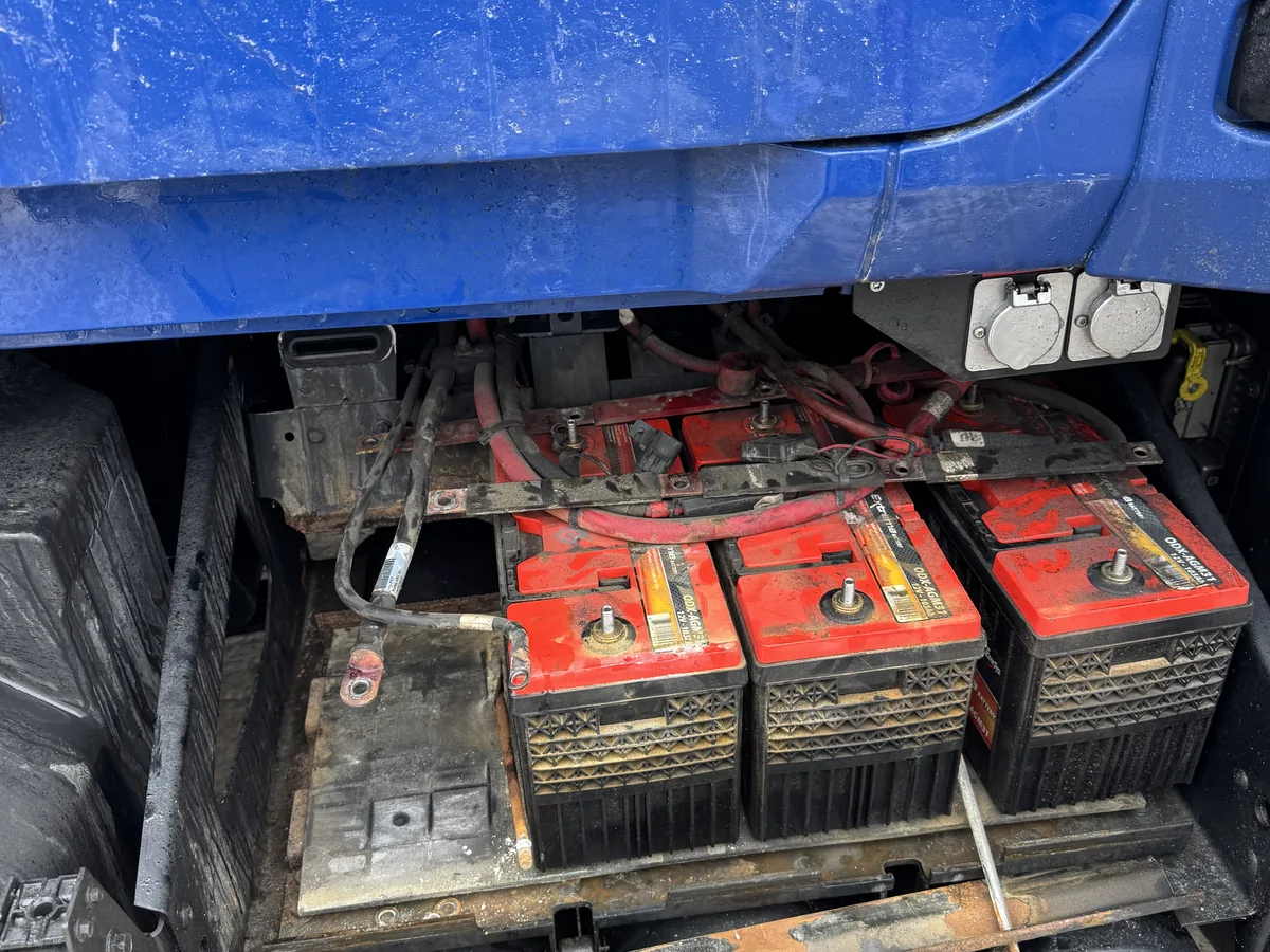 Worn batteries and corroded cables in an open truck battery box