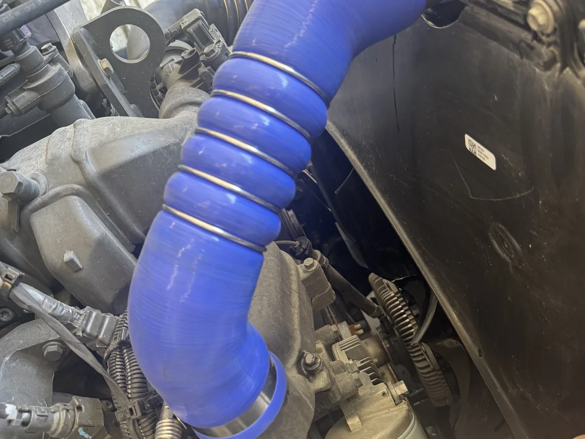 Blue silicone hose clamped in place on a truck engine